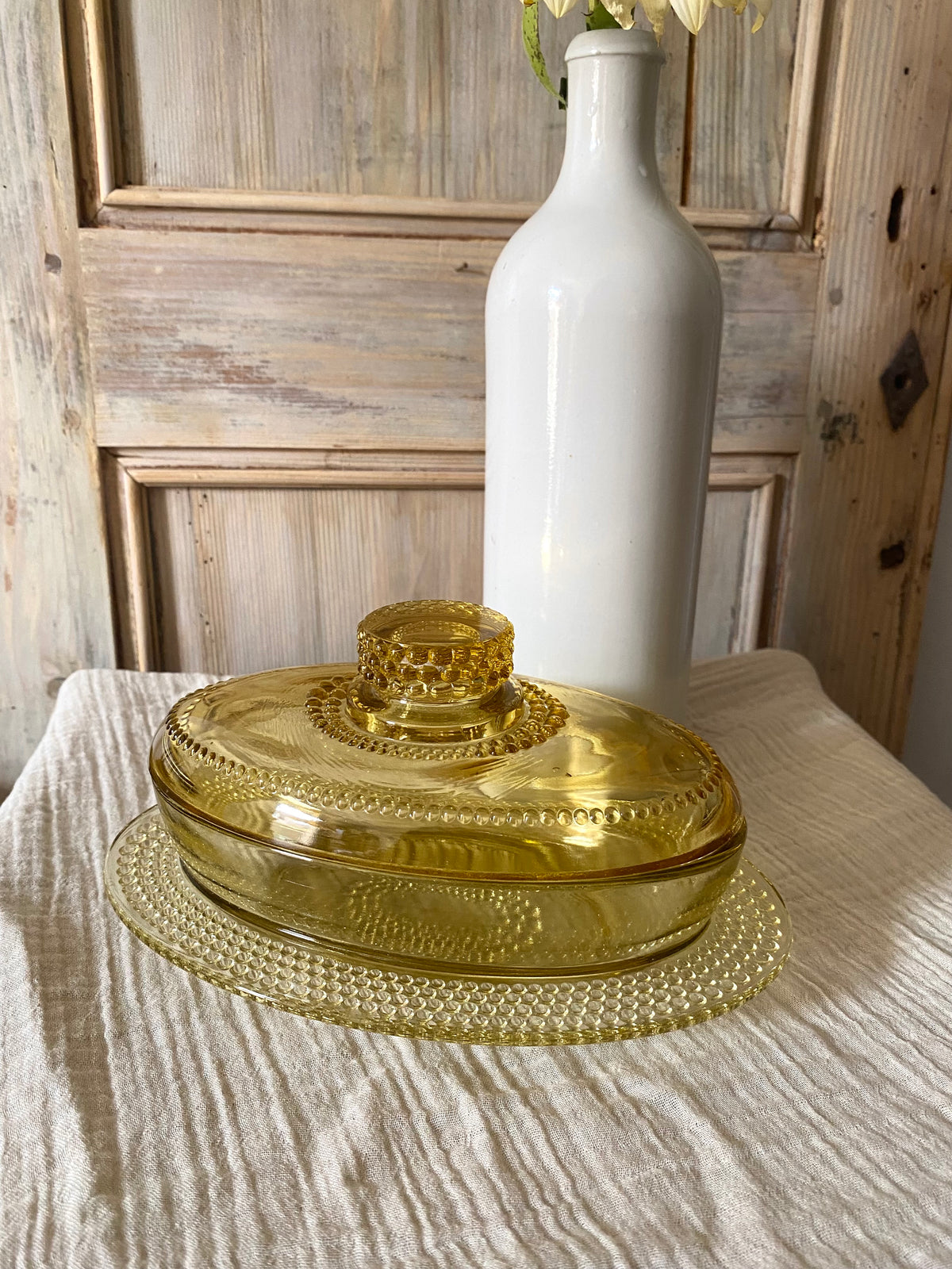 Beurrier ovale en verre ambré moulé, décor perlé - 1960