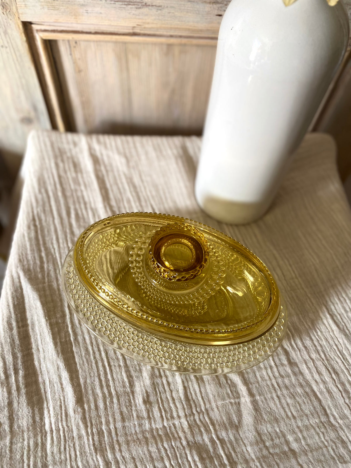 Beurrier ovale en verre ambré moulé, décor perlé - 1960