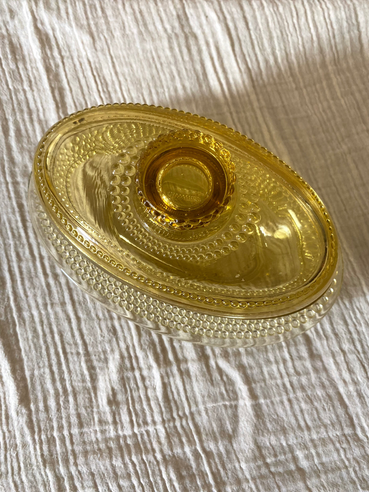 Beurrier ovale en verre ambré moulé, décor perlé - 1960