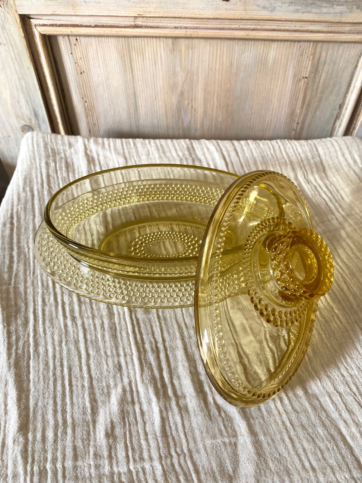 Beurrier ovale en verre ambré moulé, décor perlé - 1960