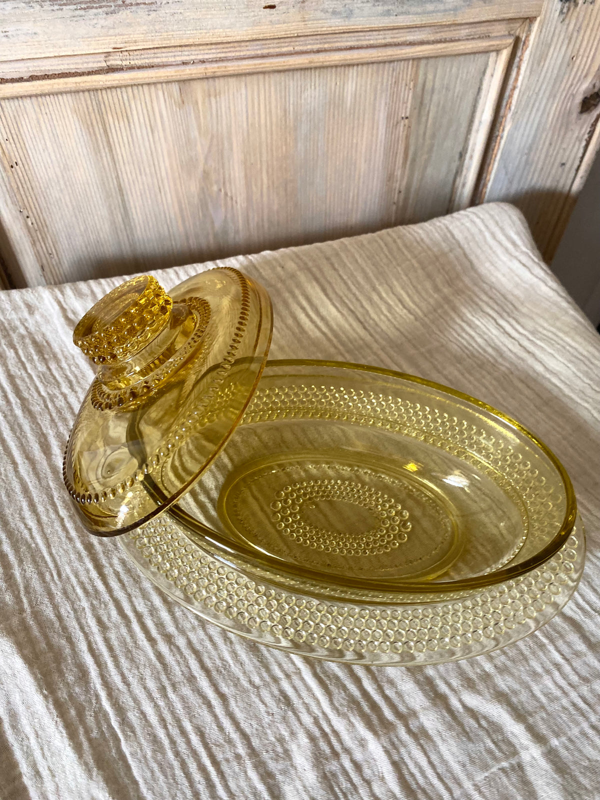 Beurrier ovale en verre ambré moulé, décor perlé - 1960